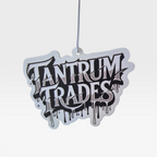 A white and black die-cut car air freshener featuring the words 'TANTRUM TRADES' in a bold black graffiti-style font with a dripping effect, against a light gray background.