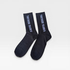 A pair of black crew socks with 'TANTRUM TRADES' logo printed in white text on the sides, displayed against a clean white background.