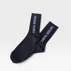 A pair of black crew socks with white logo text reading 'TANTRUM TRADES' printed vertically on the cuffs, displayed on a clean light gray background.