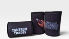 Three black neoprene can coolers on a light gray background. One cooler is shown flat with 'TANTRUM TRADES' in white logo text, and two are shown standing upright, one with a graphic of a blue tongue lizard holding and drinking a beer and the text 'Flat out like a Lizard Drinking' in white.